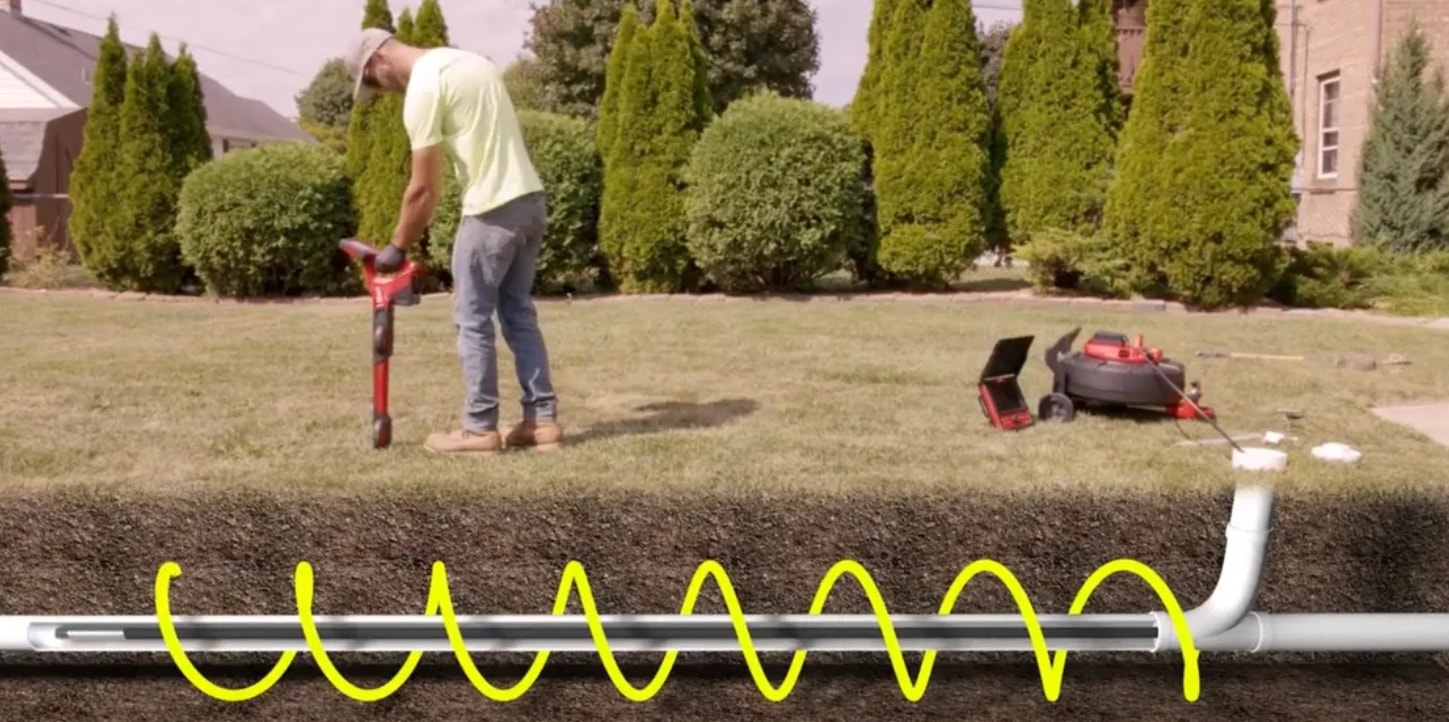 Technician using sewer camera inspection equipment to locate underground pipe damage